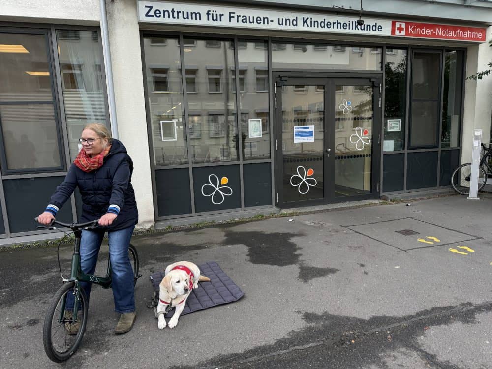 Ein Assistenzhundteam vor der Notaufnahme der Kinderklinik.