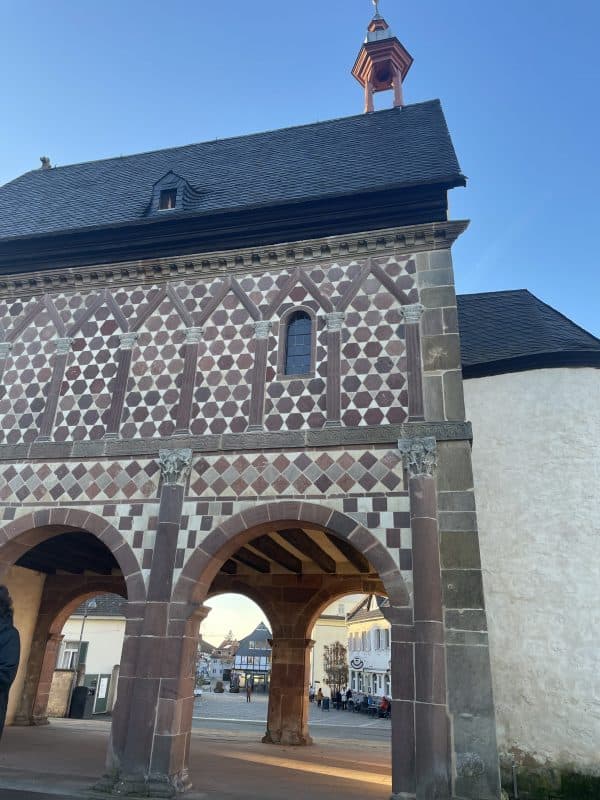 Auf dem Bild ist ein Teil der Königshalle im Kloster Lorsch. Unten sind offene Rundbögen, oben ein geschlossener Quader.